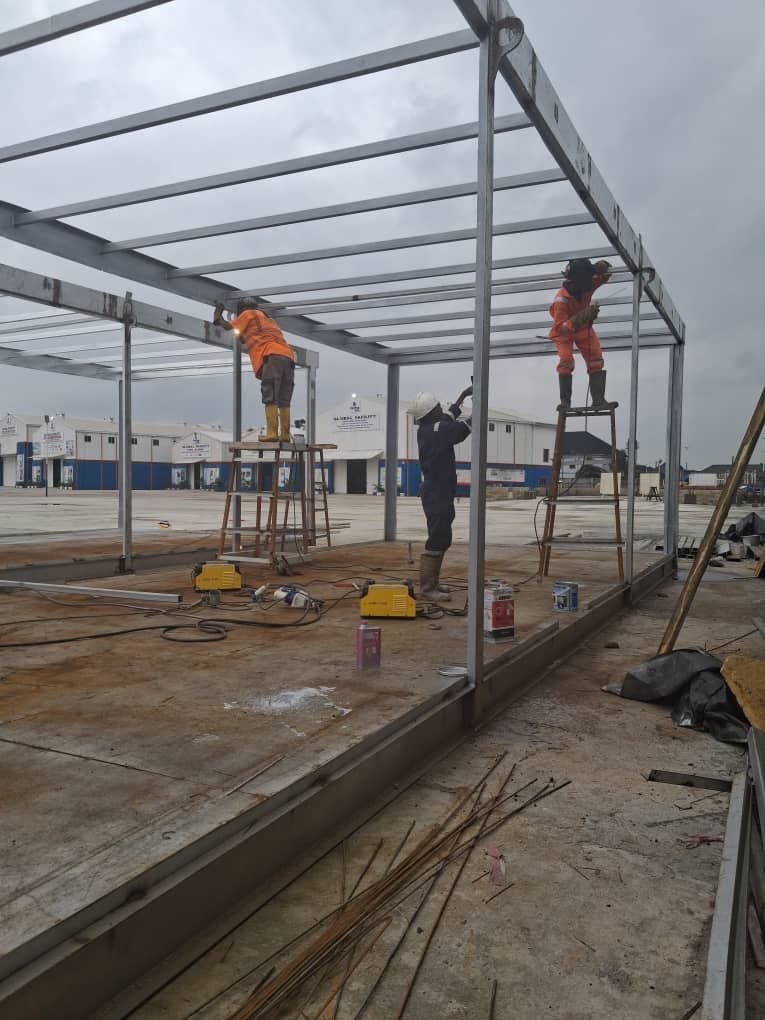 Crew in full PPE mounting structural steel roof beams - Proof of safety & field execution